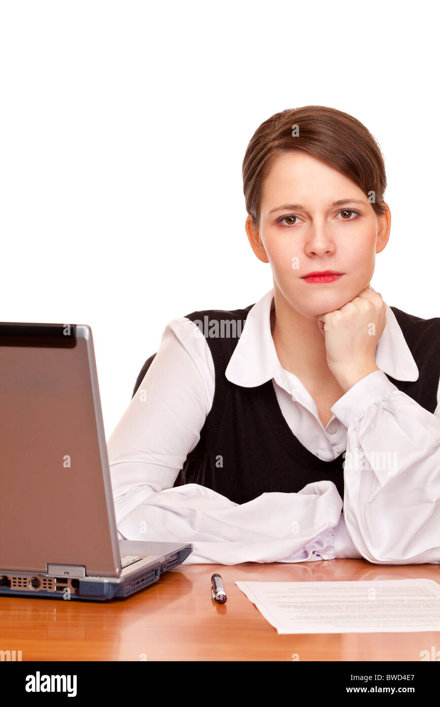 Young serious business woman sits on desk in office. Isolated on white background. Stock Photo