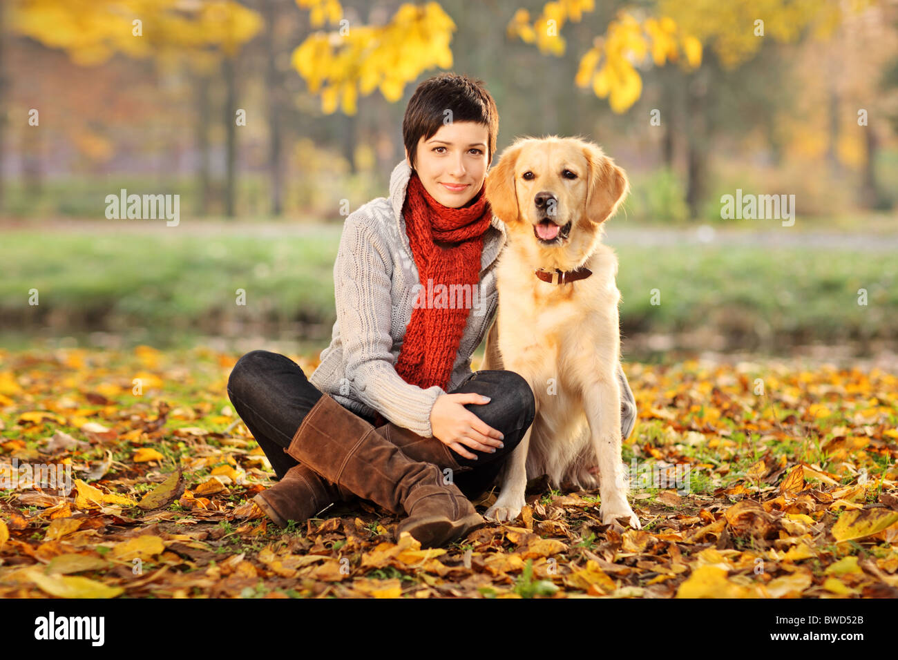 A beautiful woman and his dog (Labrador retriever) posing outside Stock Photo