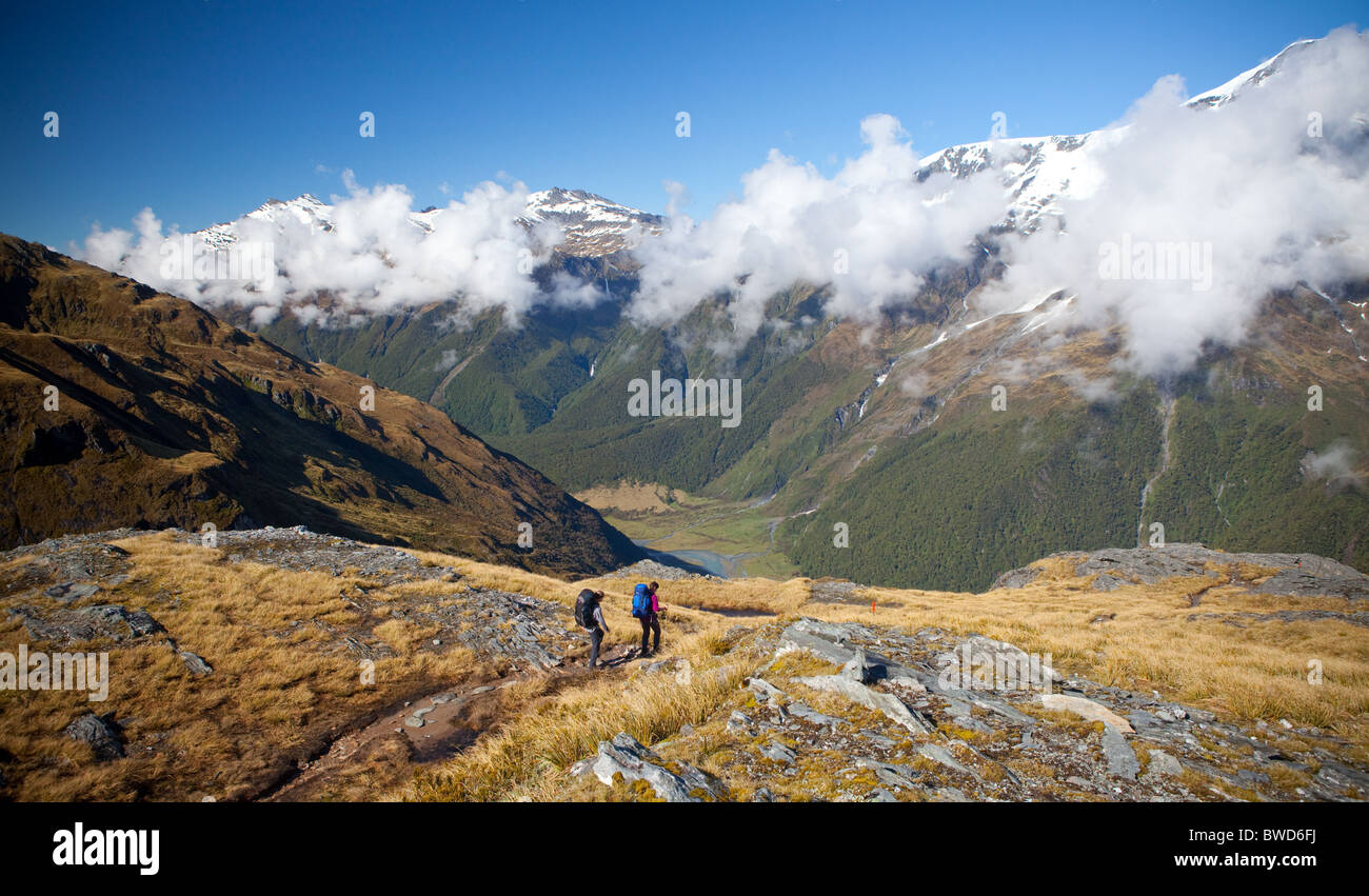 Two hikers walking down into the Matukituki Valley of the South Island of New Zealand Stock Photo