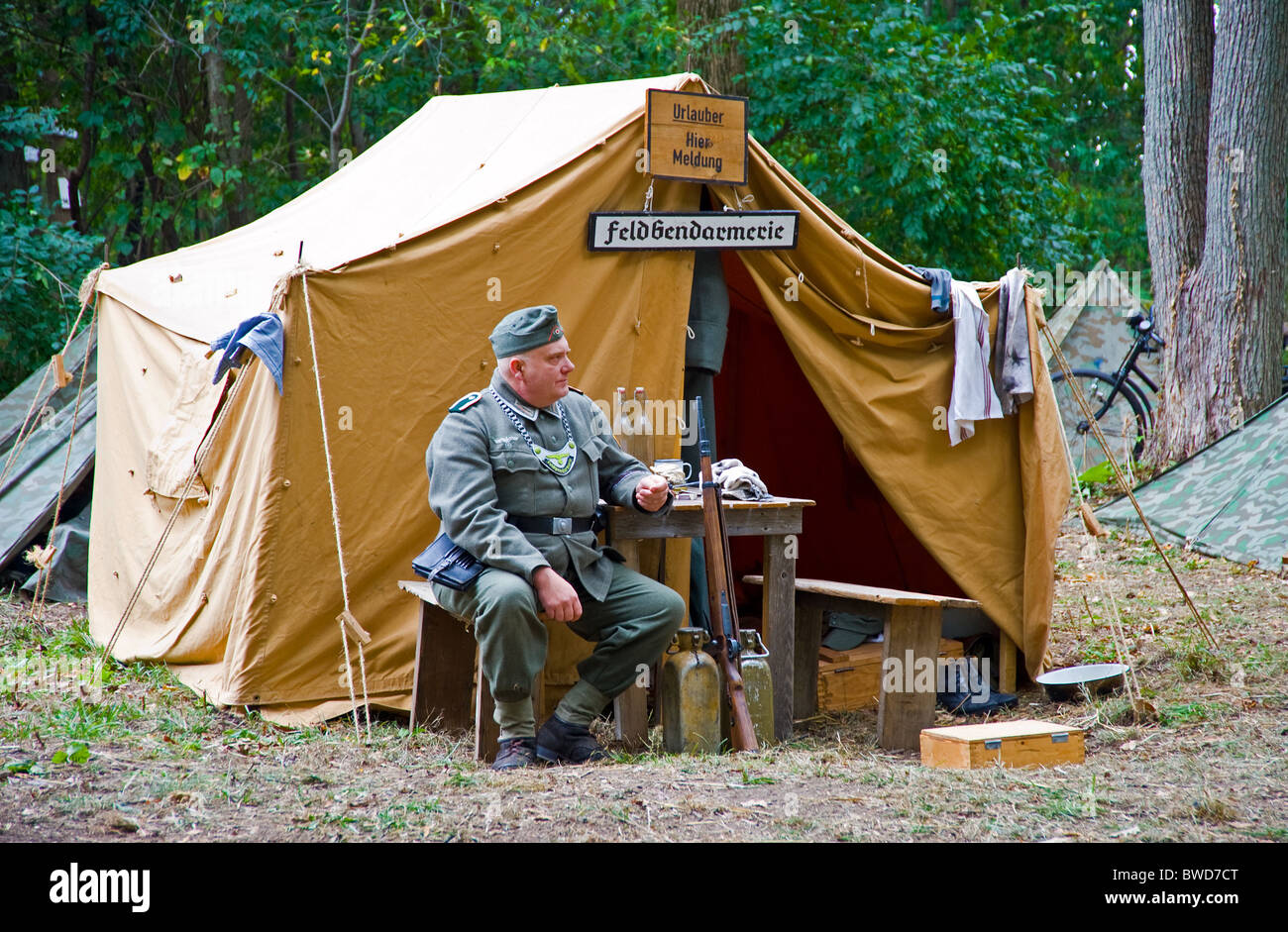 German army officer world war two time sitting near tent camp camping acting show wood forest Stock Photo