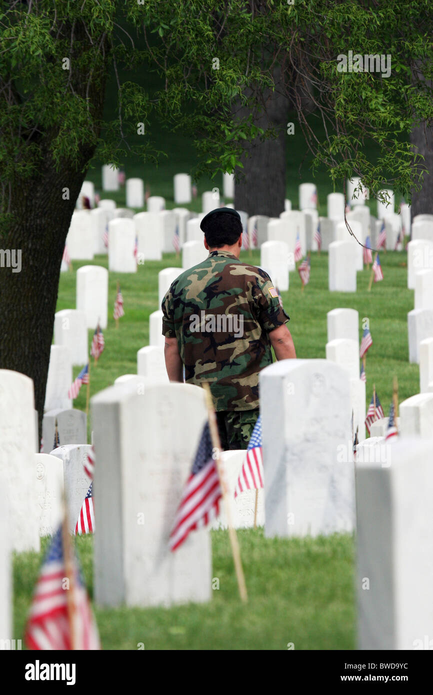 A veteran walking through the grave sites covered with American flags at Clement J Zablocki Veterans Cemetery Wisconsin Stock Photo
