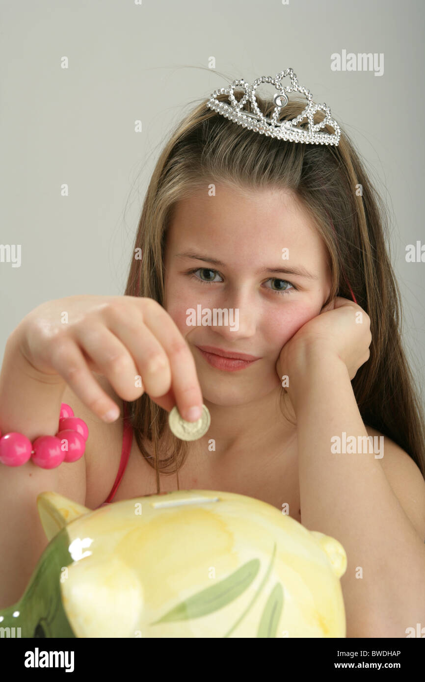 Ten year old girl putting money into her piggy bank Stock Photo - Alamy