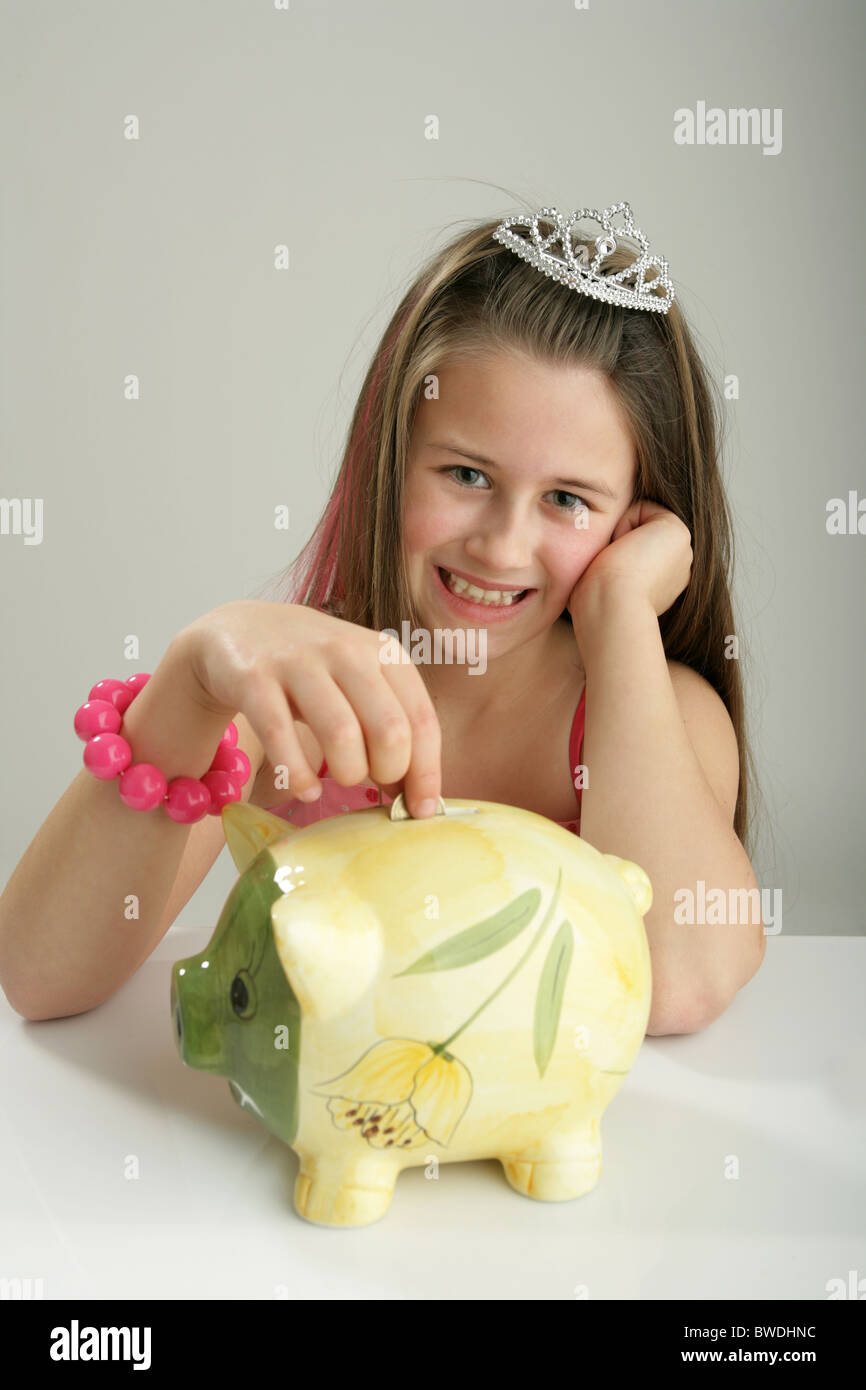 Ten year old girl putting money into her piggy bank Stock Photo - Alamy