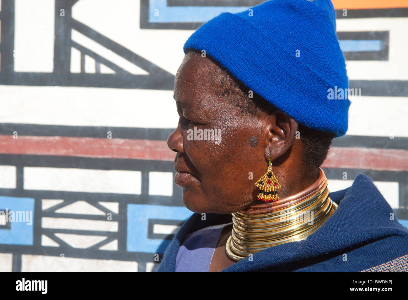 Traditional Ndebele Woman in Neck Rings with Ndebele Murals, Kwandebele Area, South Africa Stock Photo