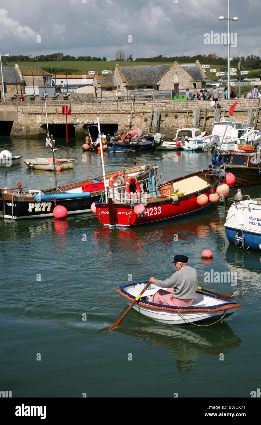 Coming ashore from his boat in the harbour at West Bay, a popular seaside resort near Bridport on West Dorset's Jurassic Coast Stock Photo