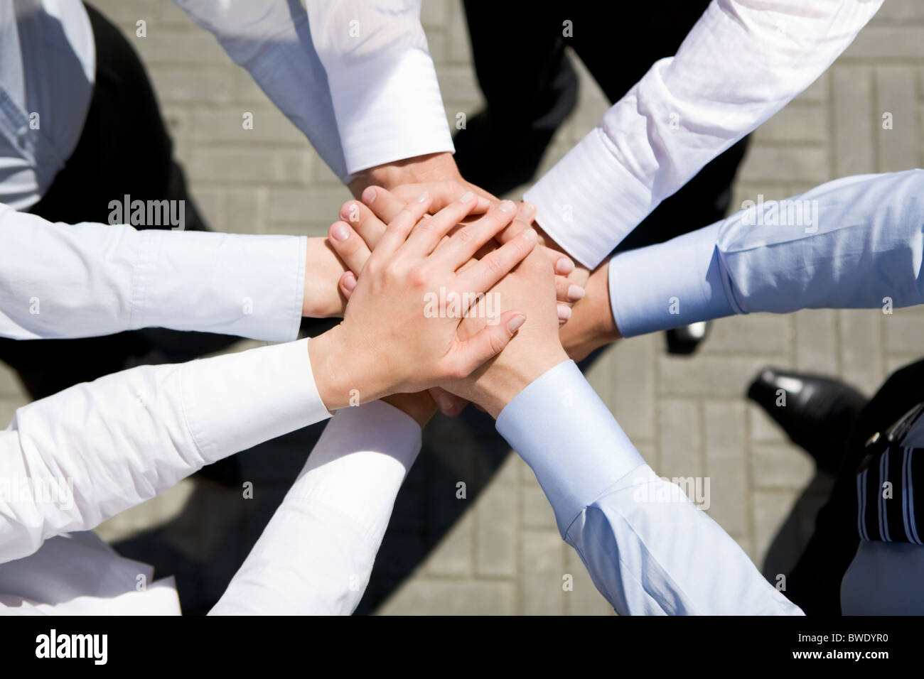 Above view of business partners hands on top of each other symbolizing  companionship and unity Stock Photo - Alamy