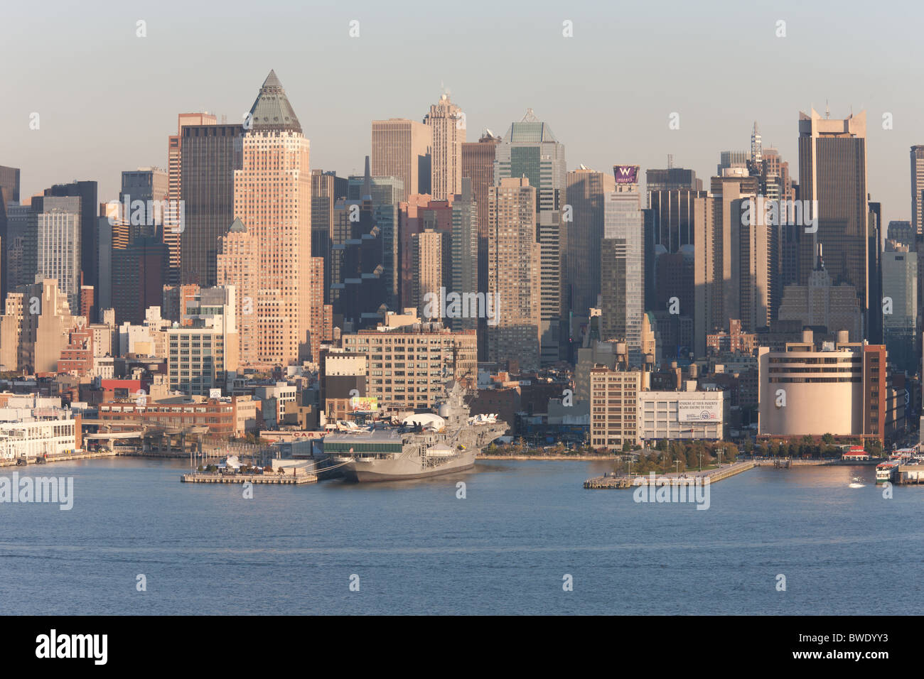 The midtown Manhattan skyline behind the Intrepid Sea, Air and Space Museum on the Hudson River in New York City. Stock Photo
