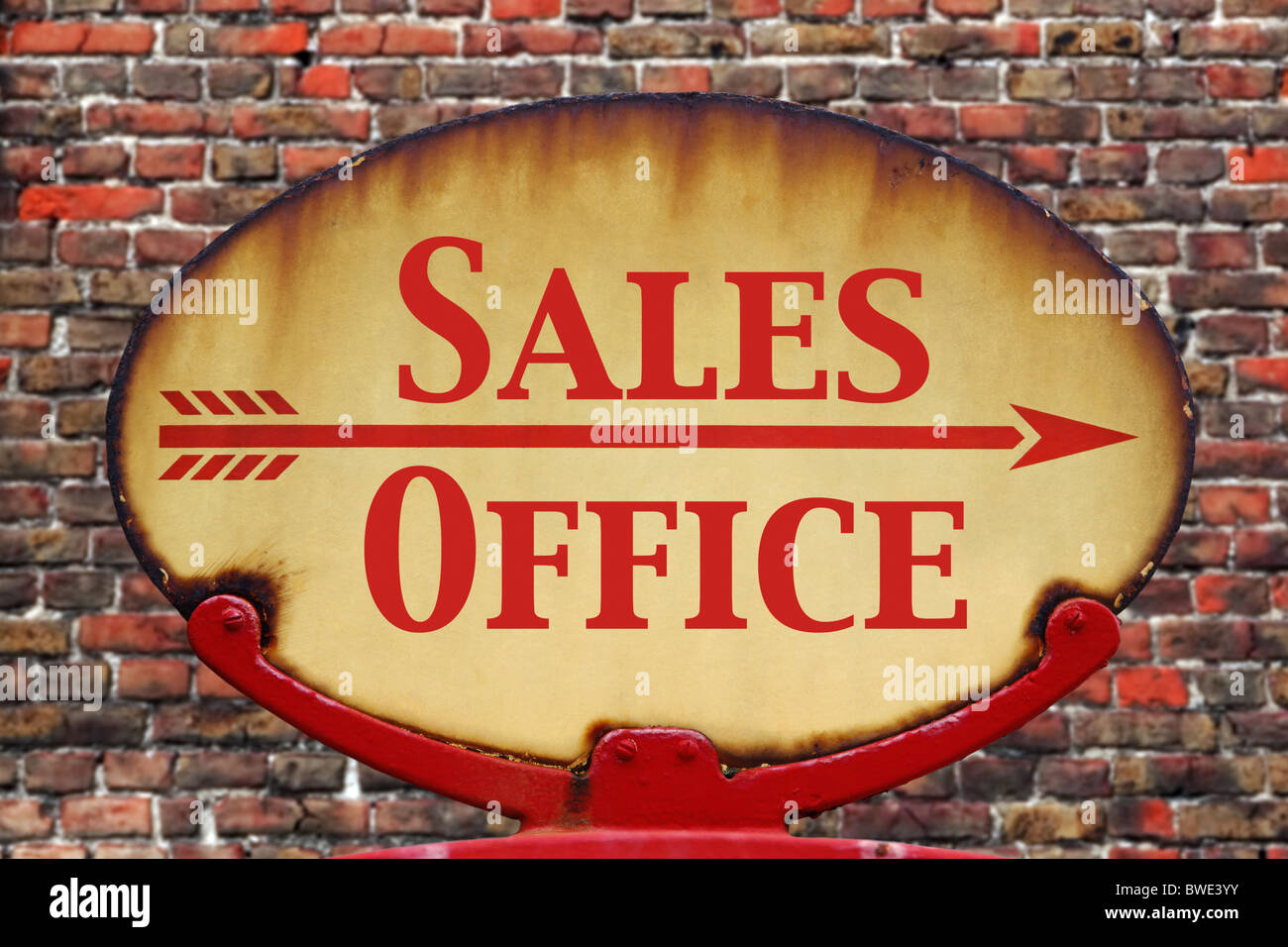 A rusty old retro arrow sign with the text Sales Office Stock Photo