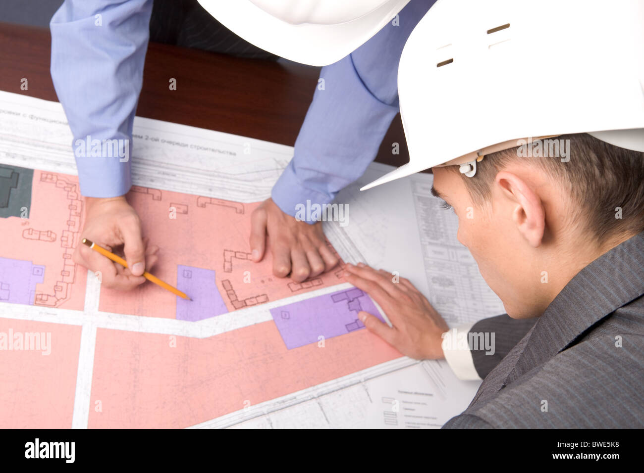 Above view of engineers over blueprints during discussion Stock Photo ...