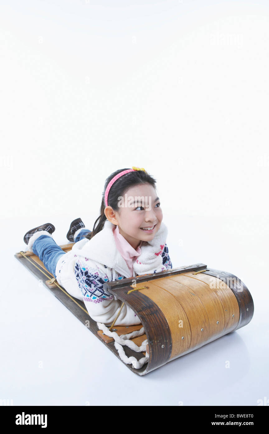 girl laying on stomach on the sled Stock Photo
