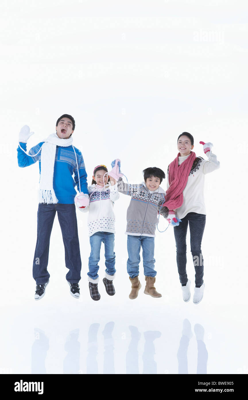 family is jumping up in winter goods Stock Photo