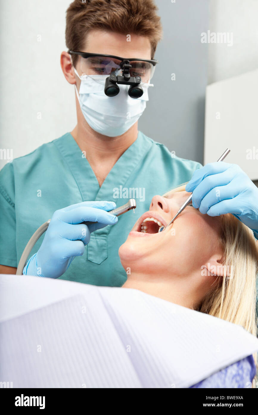 Male dentist examining a female's teeth Stock Photo