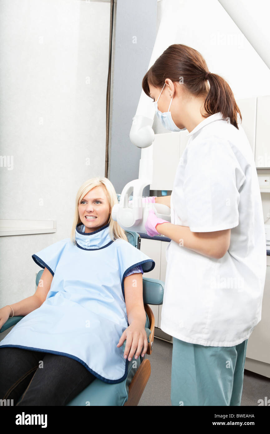 Female dental assistant taking oral x-ray of a patient Stock Photo
