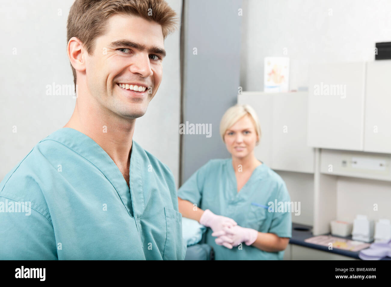 Portrait of male dentist with female assistant standing at dental clinic Stock Photo