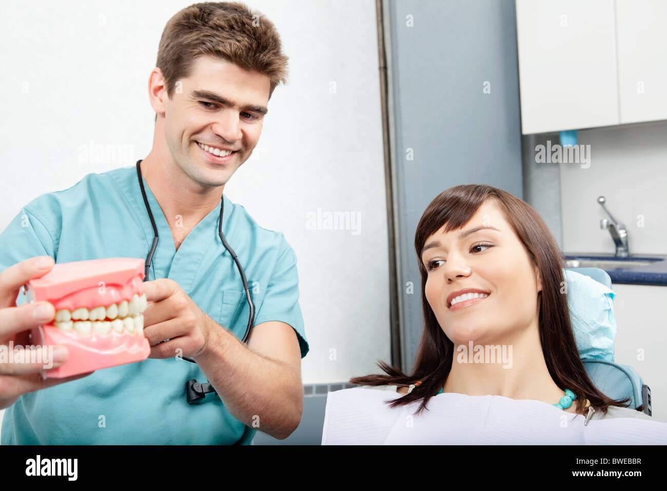 Male dentist explaining a female patient denture work in dental clinic Stock Photo
