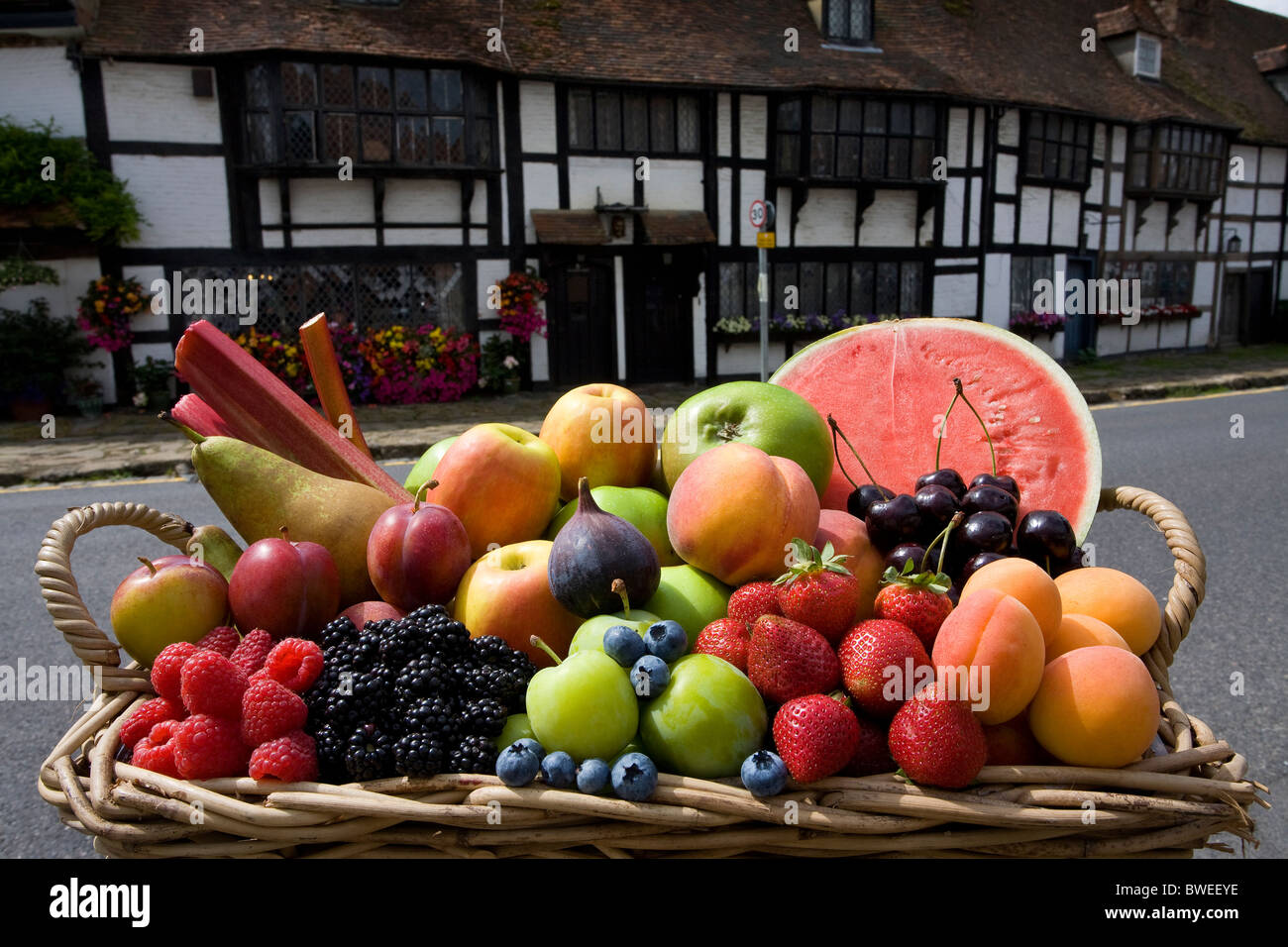 Basket of locally grown delicious healthy British summer fruits in historic tudor village street Biddenden Kent UK Stock Photo