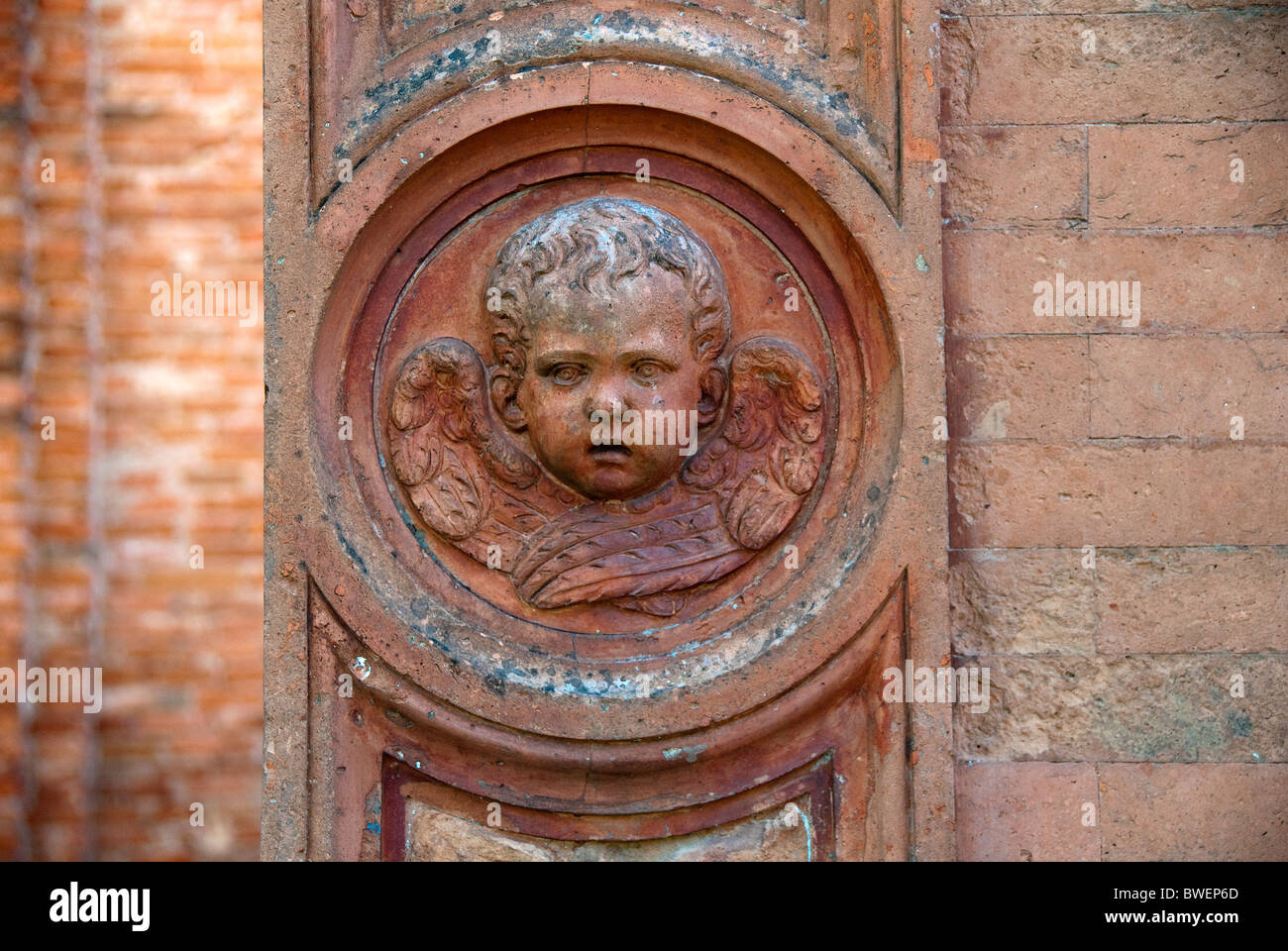 Detail of an angels face in a rondel in the gate of the cimitero della Certosa, or Cemetery of Certosa, Ferrara matches BWENY4 Stock Photo