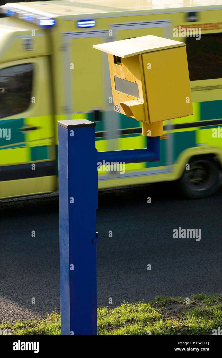 speeding ambulance speeds past speed camera Stock Photo