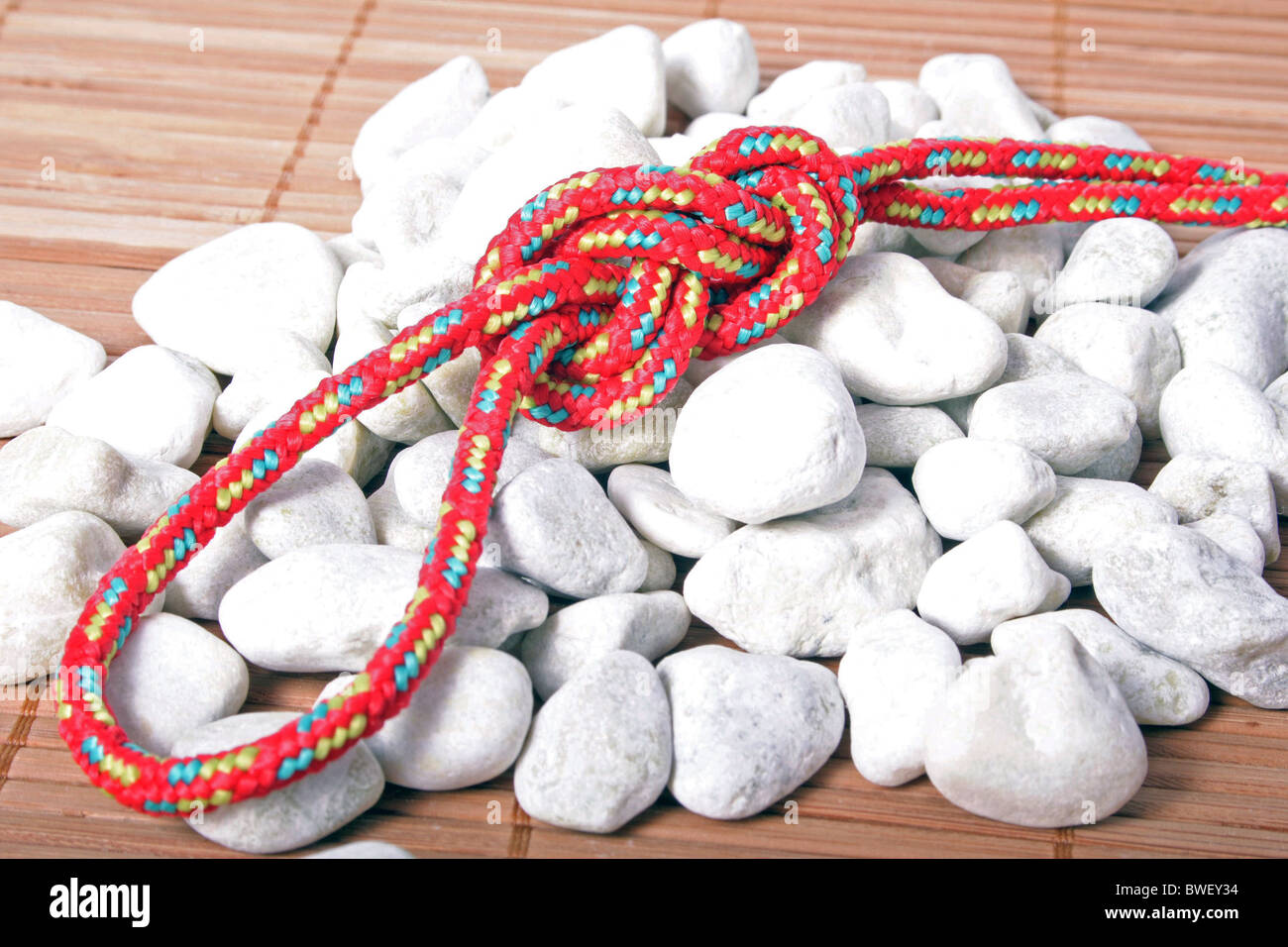 A fine knotted bowline knot lying on a pile of rocks Stock Photo - Alamy