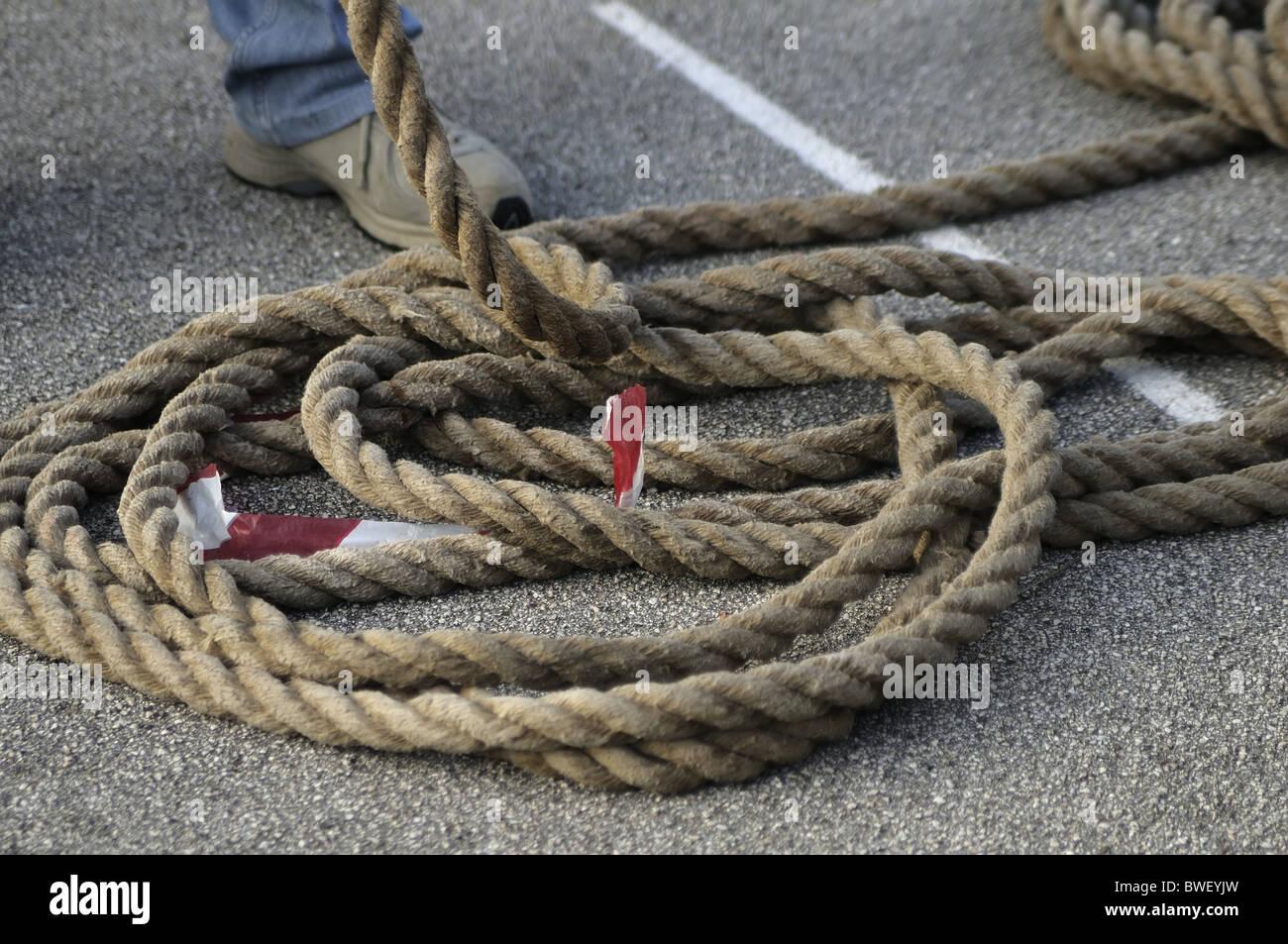 Detail of a rope that is coiled on the ground Stock Photo - Alamy
