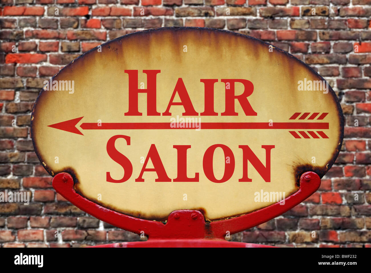 A rusty old retro arrow sign with the text Hair salon Stock Photo