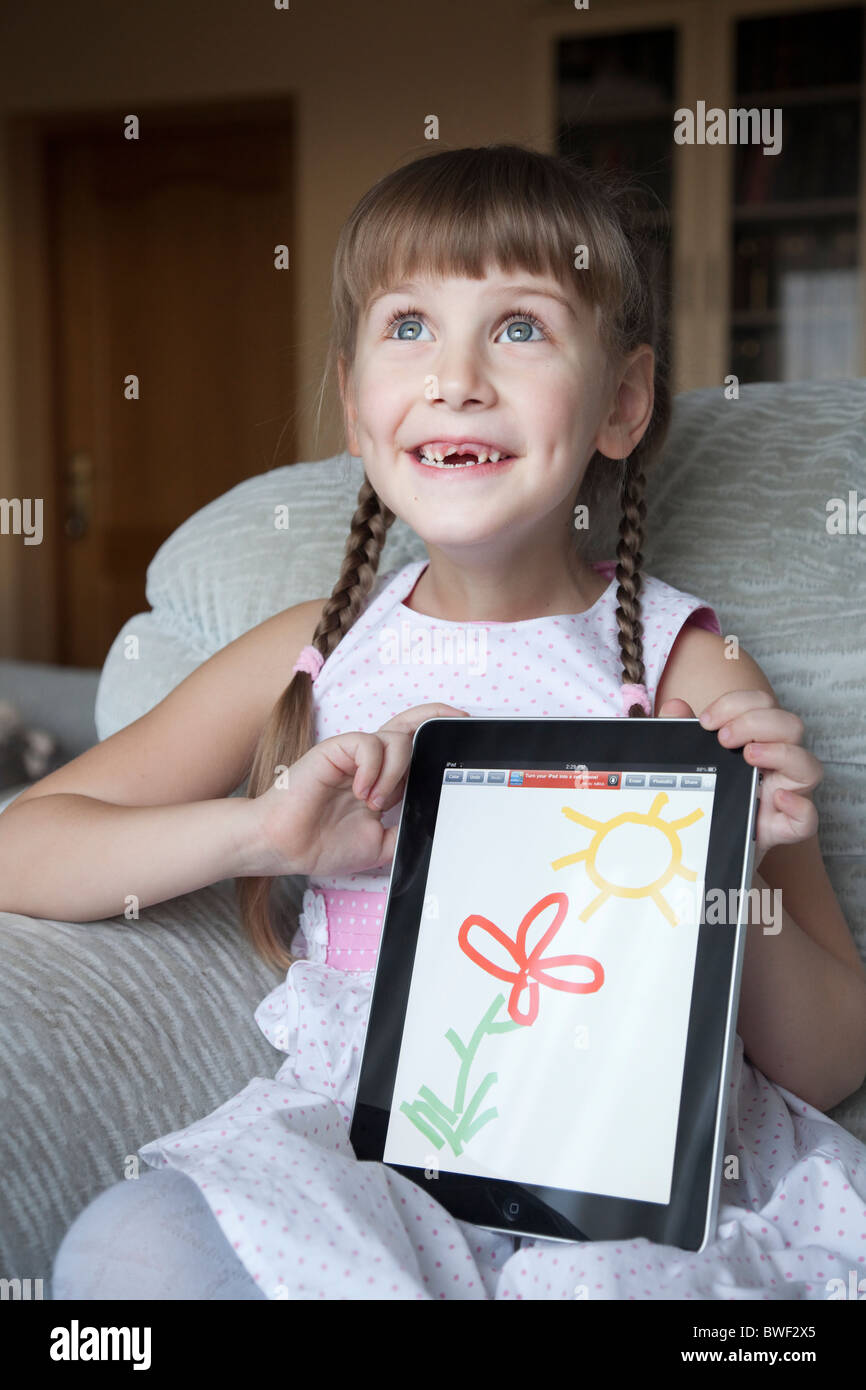 Little girl is using Apple iPad to draw and entertain herself at home