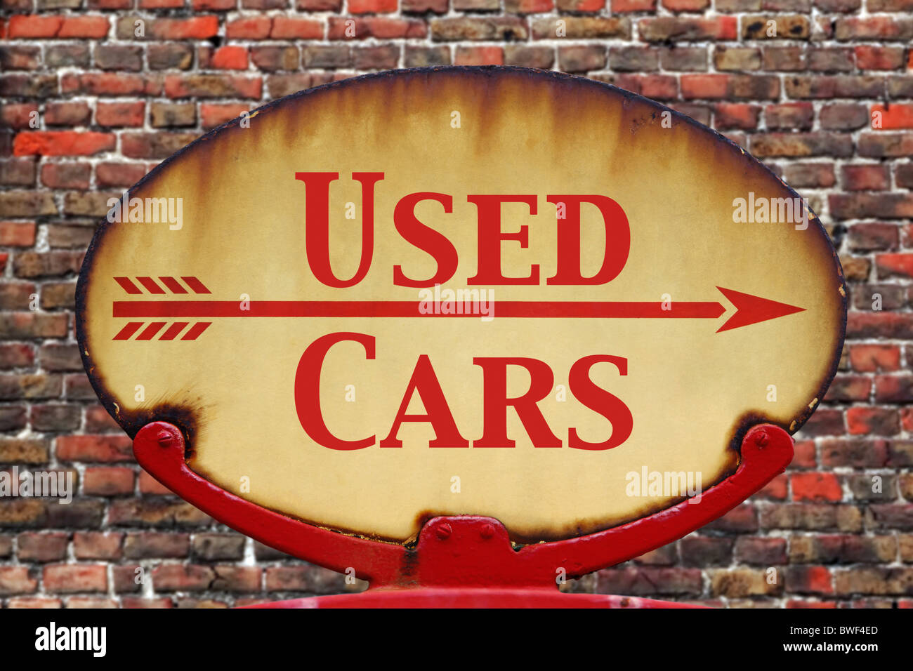 A rusty old retro arrow sign with the text Used cars Stock Photo