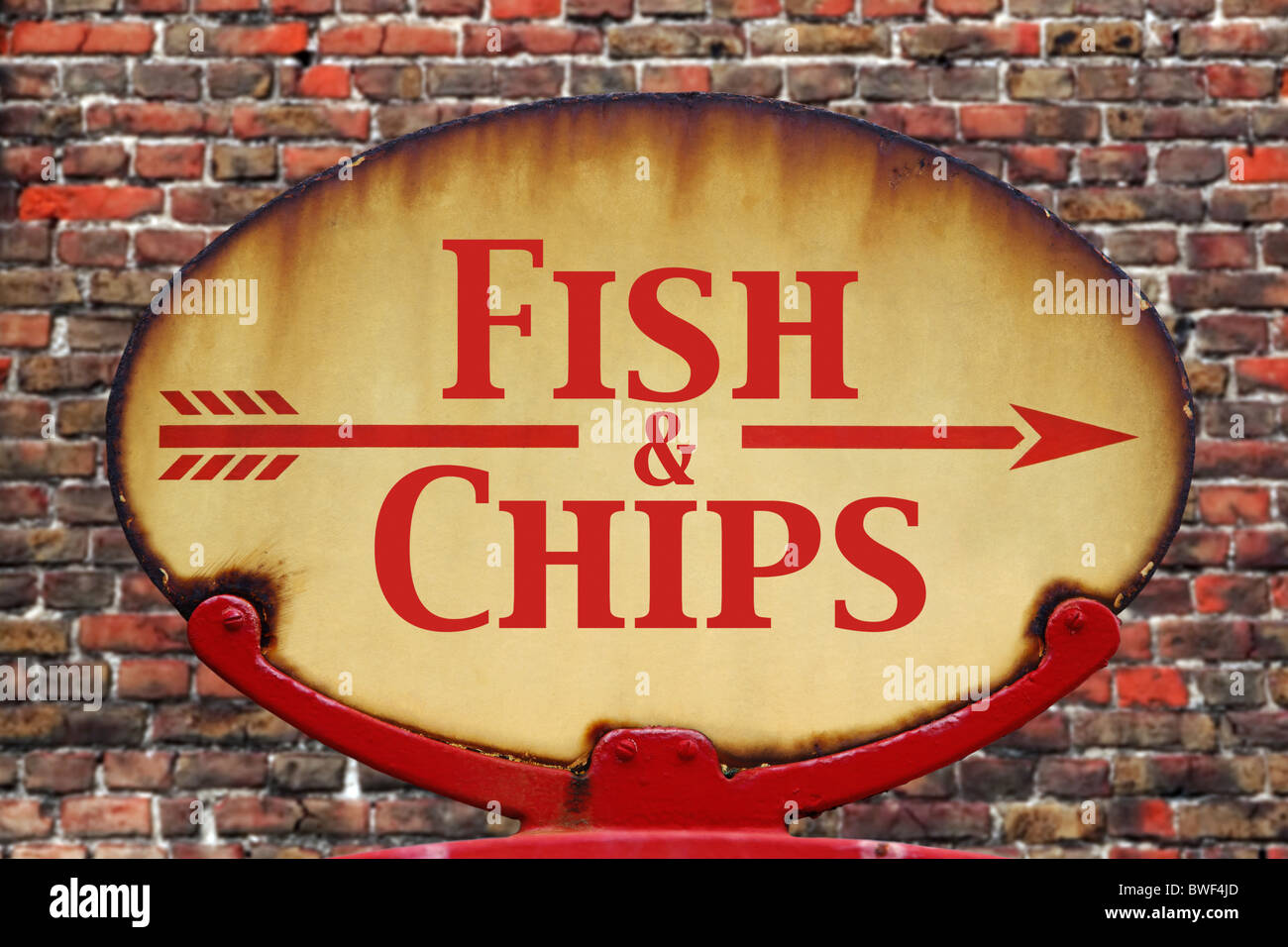 A rusty old retro arrow sign with the text Fish and chips Stock Photo