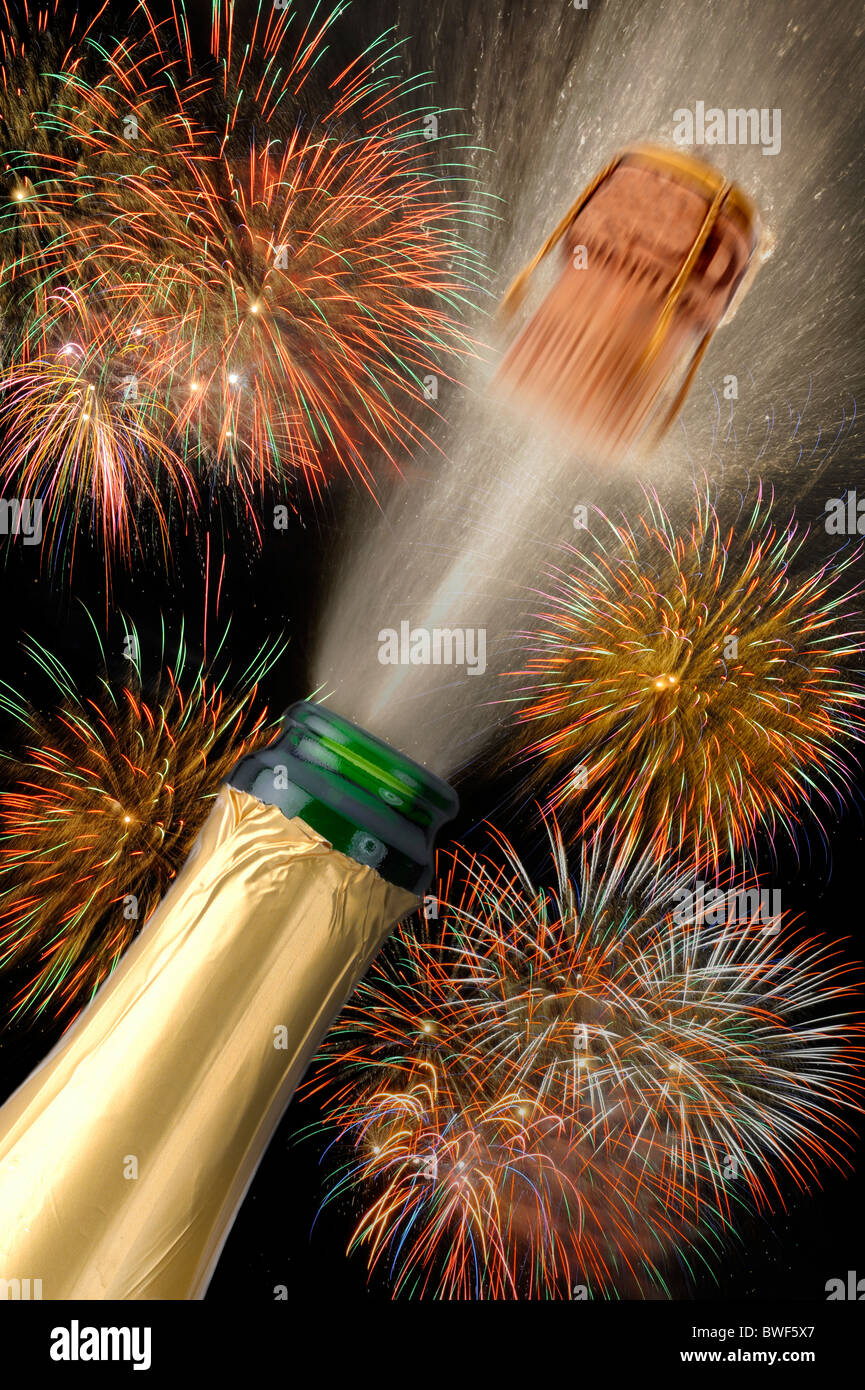 champagne bottle popping at new year eve party with firework at ...