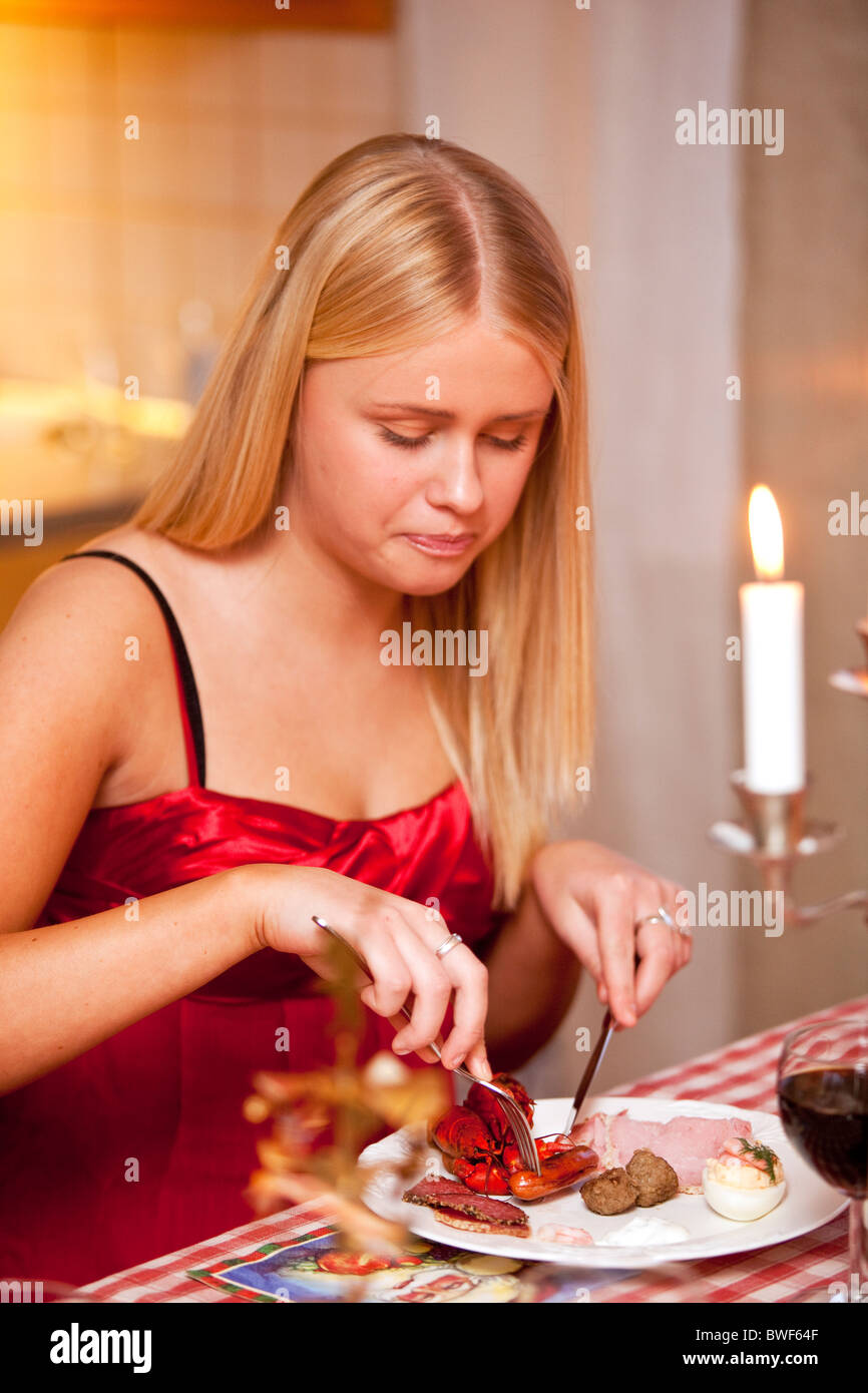 Young woman eating Christmas dinner.Sweden Stock Photo