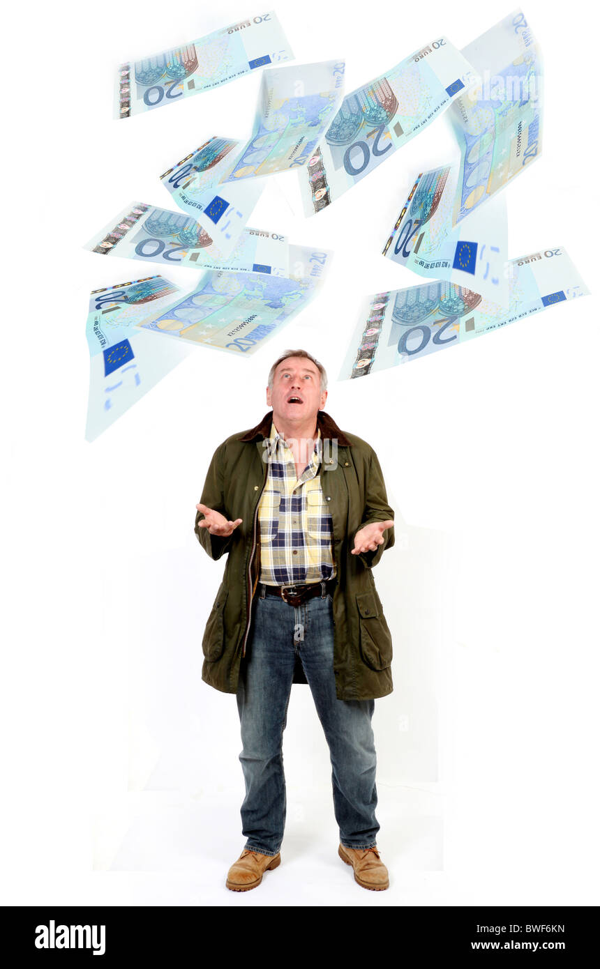 Man looking up catching €20 notes floating down Stock Photo