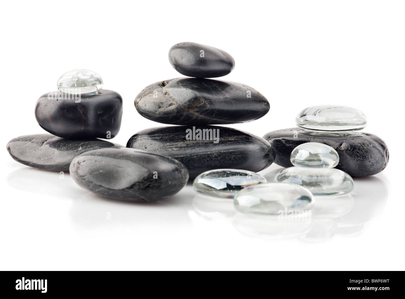 Natural black stones and transparent glass drops in pyramid over white Stock Photo