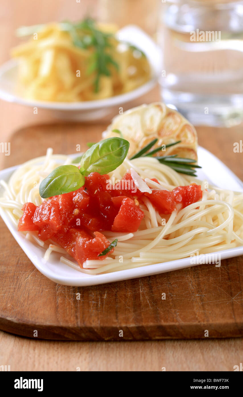 Spaghetti, peeled tomato and baked garlic Stock Photo