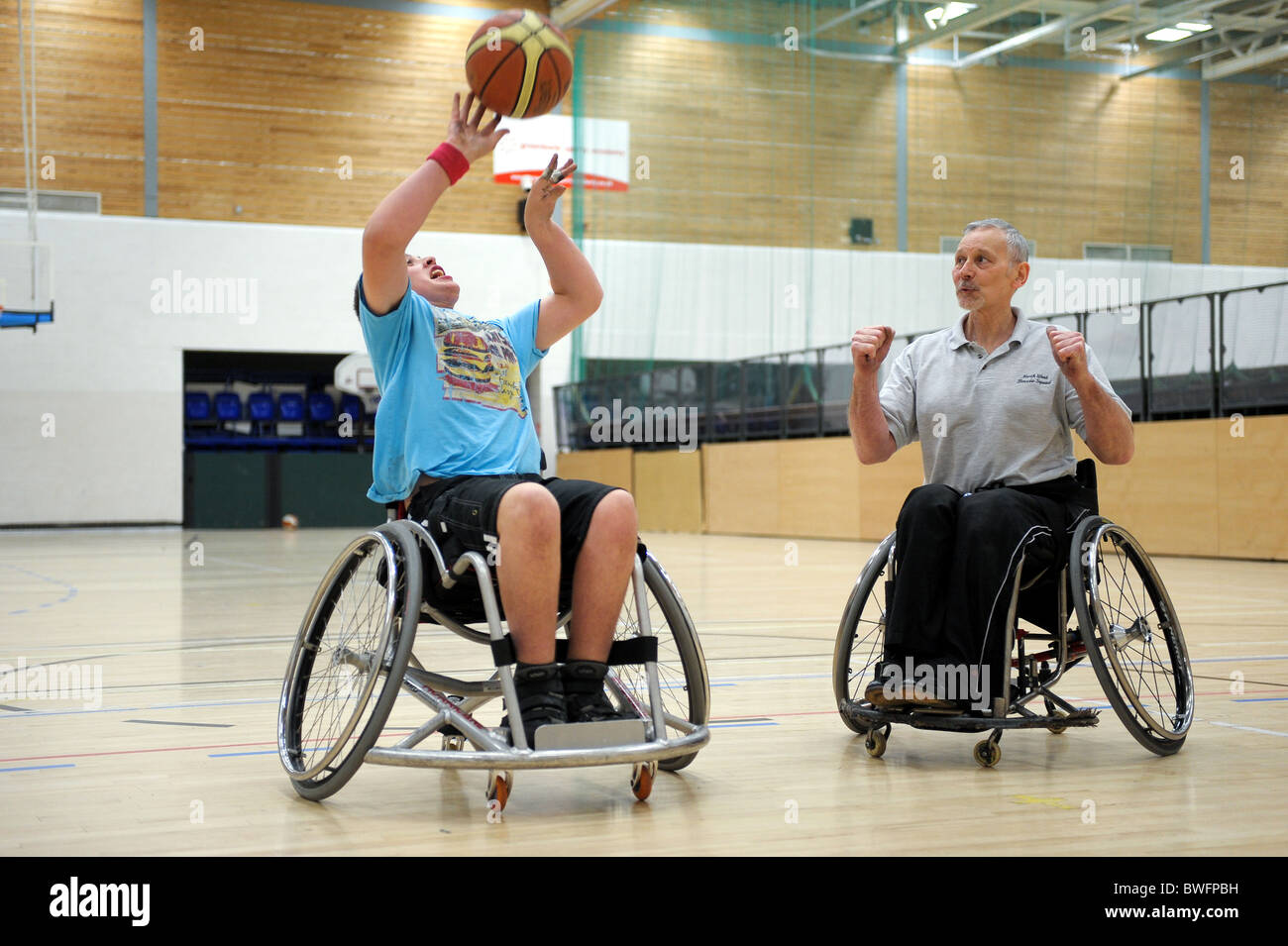 A coach gives instructions to a wheelchair basketball player Stock