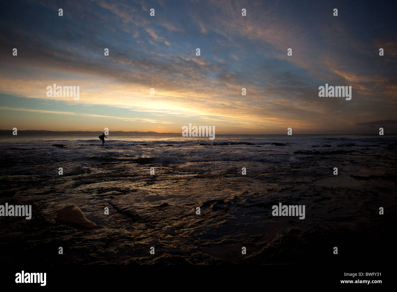 A Colourful sunrise for Surfer, Supertubes,Jeffreys Bay South Africa Stock Photo