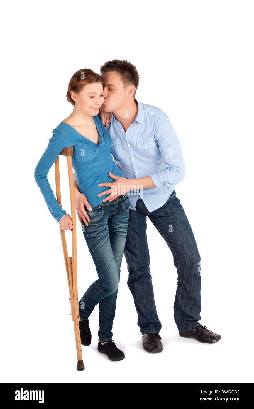 Gentle man cheer up his injured girlfriend using crutch to walk isolated on white Stock Photo