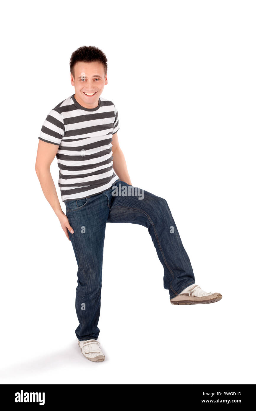 Young happy easygoing casual man standing on one leg isolated on white background Stock Photo