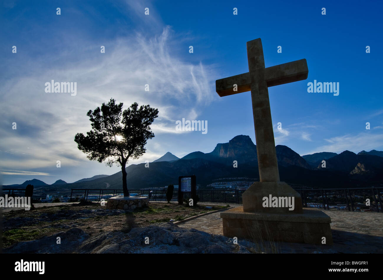 A cross against a blue cloudy sky in the town of La Nucia, Spain Stock Photo