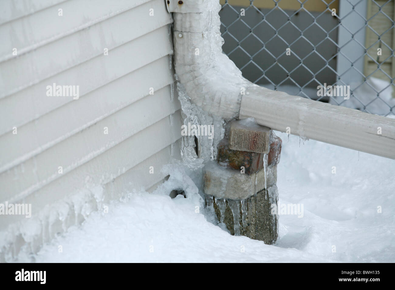 ice and icicles on the gutter downspout of a house Stock Photo Alamy
