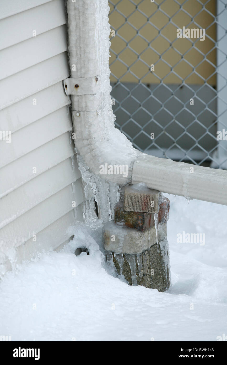 ice and icicles on the gutter downspout of a house Stock Photo Alamy