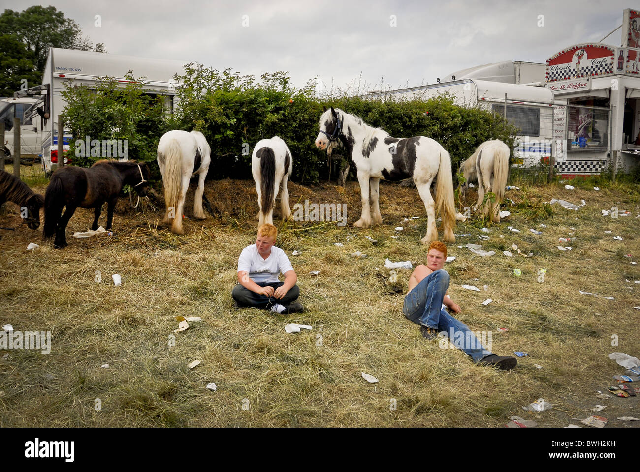 two boys watch over their horses passing the time - Stock Image