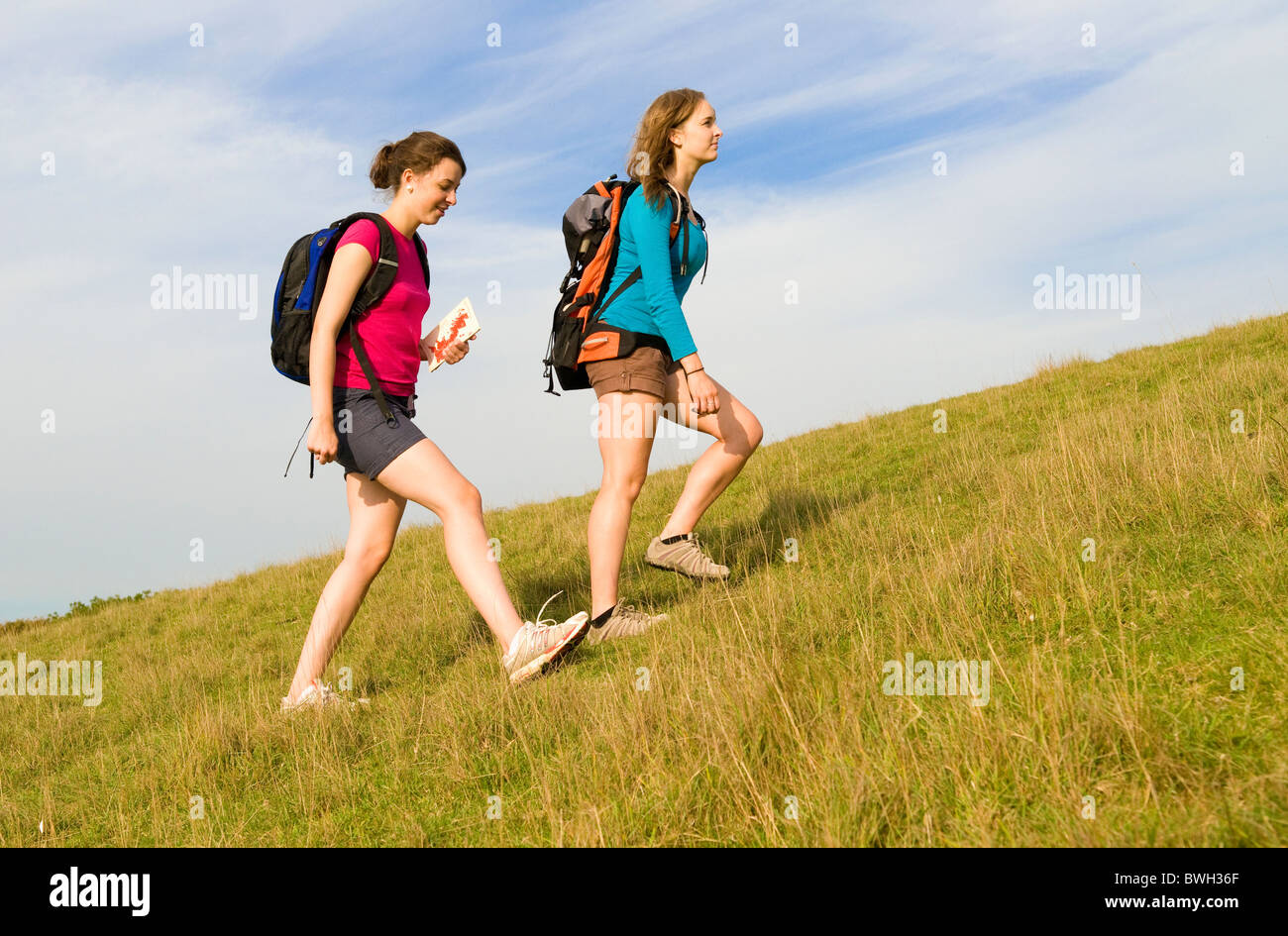 Two hikers climb hill Stock Photo - Alamy