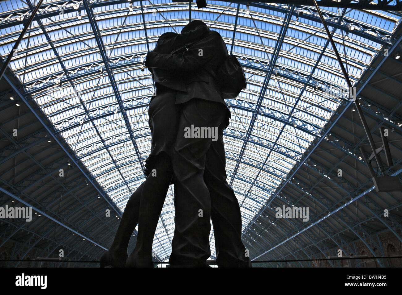 Statue of a kissing couple against the roof of St Pancras international railway station, London Stock Photo