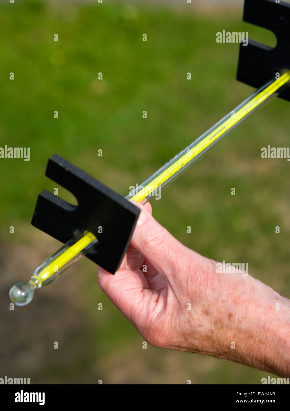 Climate Weather Station Measurements Weather observer reading thermometer that measures grass temperature during the night Stock Photo