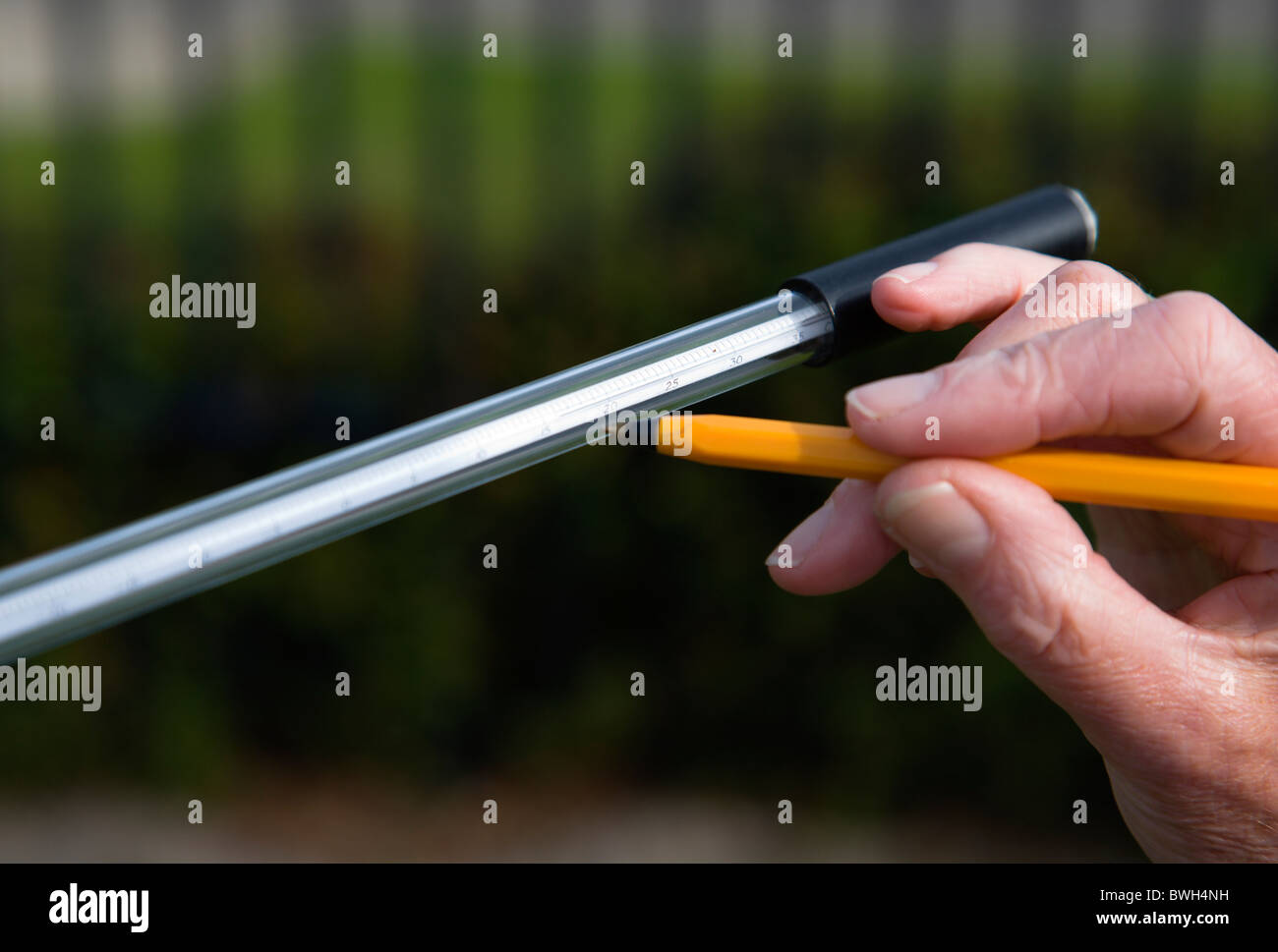 Climate Weather Station Measurements Weather observer reading thermometer that measures overnight minimum concrete temperature Stock Photo