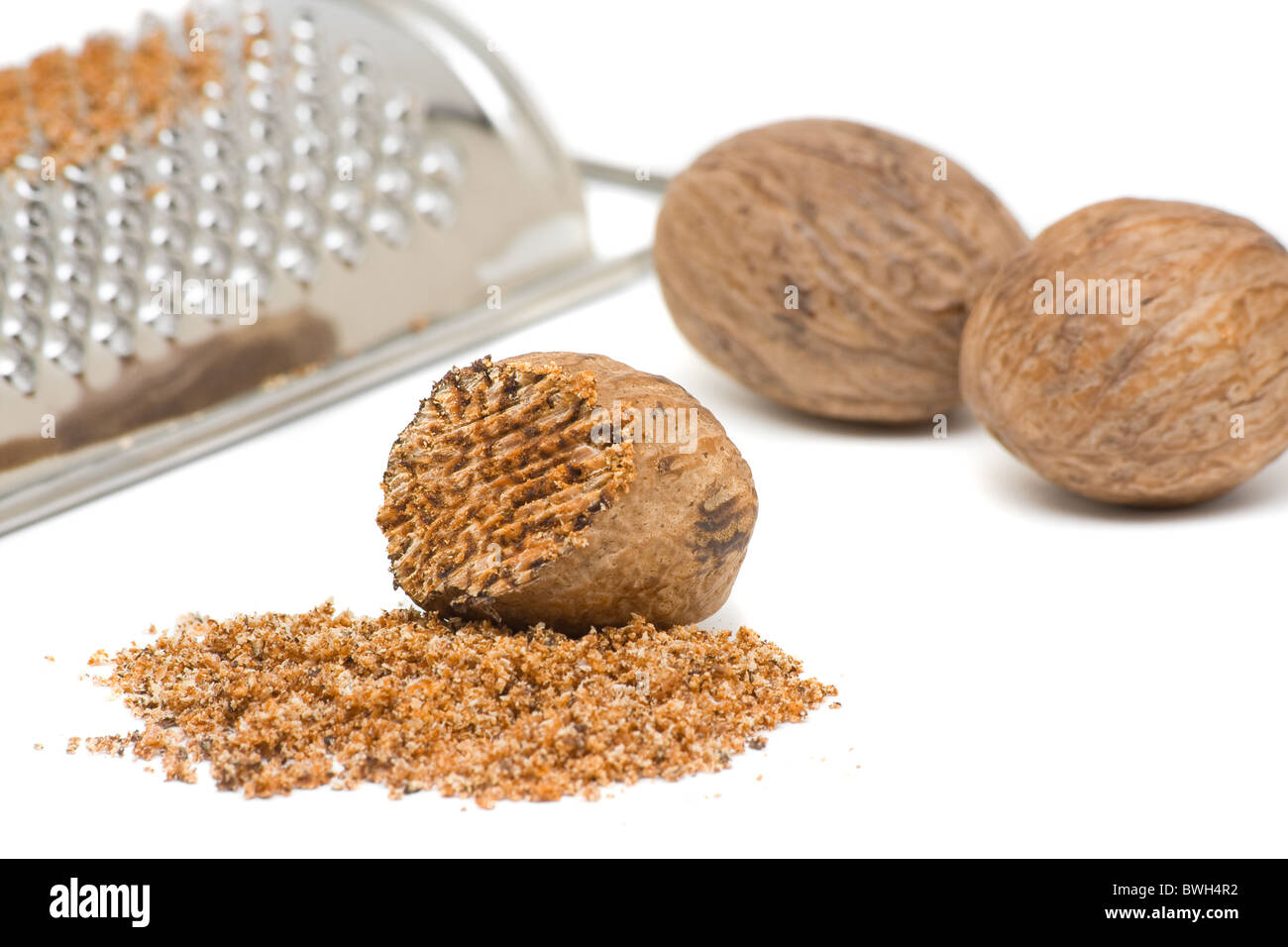 Whole and grind nutmeg with grinder over white background Stock Photo