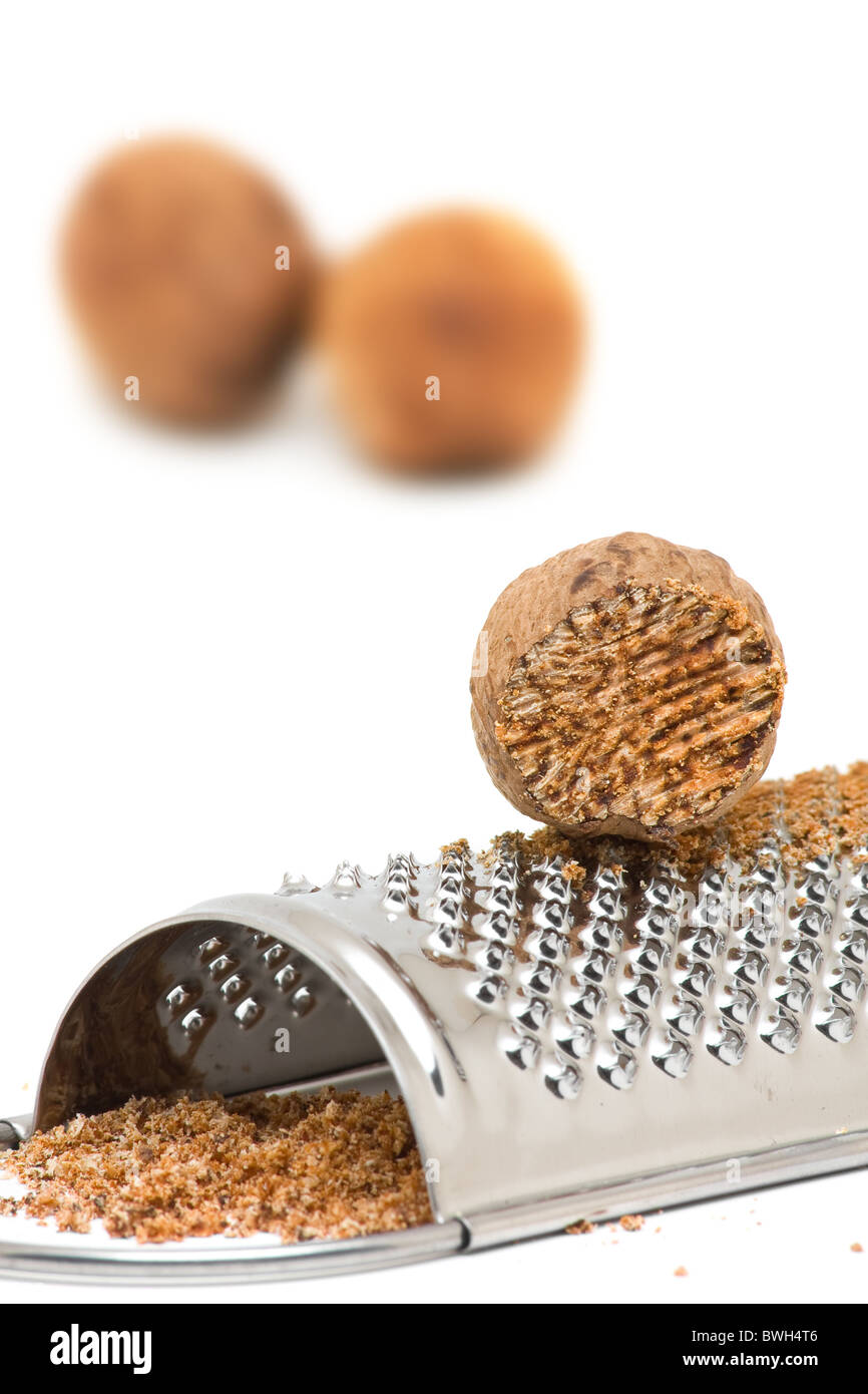 Whole and grind nutmeg with grinder over white background Stock Photo