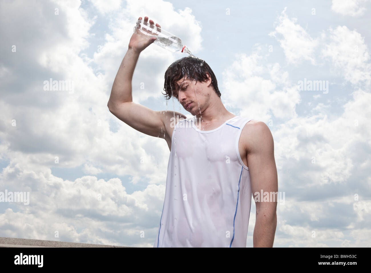 Male runner pouring water over head Stock Photo Alamy