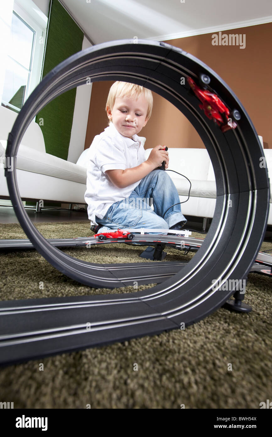 Boy playing with slot car racing track Stock Photo