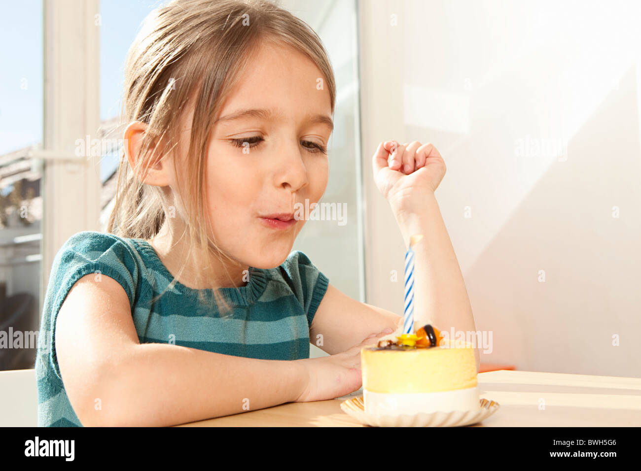Girl blowing out candle on birthday cake Stock Photo Alamy